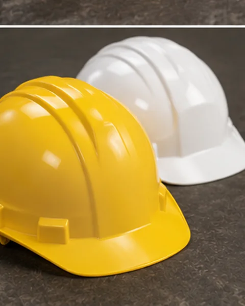 Close-up of yellow and white industrial safety helmets